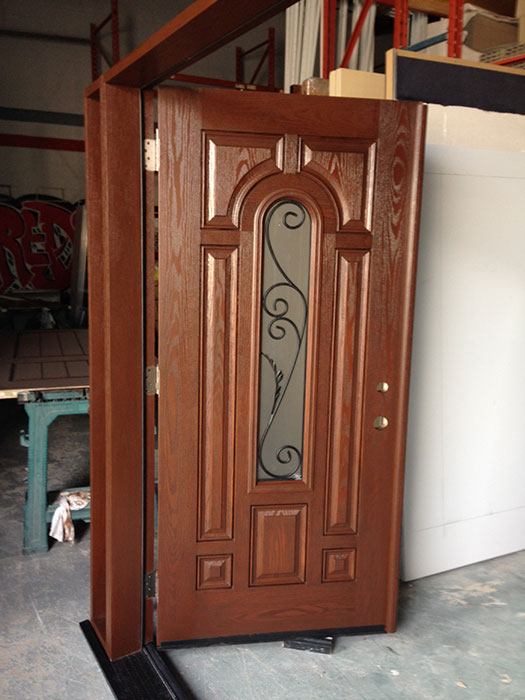 8 Panel Fiberglass Woodgrain Front Doors with Clear Glass Side Lites and Transom with Iron Art Designs During Manufacturing by windowsanddoorstoronto.ca