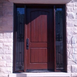 Fiberglass Woodgrain Rustic Front Door with 2 Frosted Side Lites and Iron Art Design installed by windowsanddoorstoronto.ca